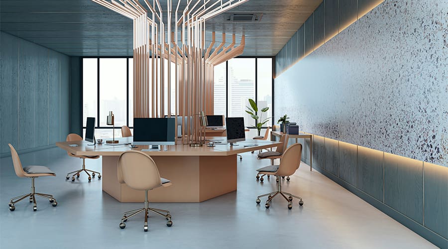 Interno di ufficio contemporaneo con scrivania centrale condivisa, sedie girevoli, monitor desktop e struttura luminosa sospesa dal design geometrico, in ambiente elegante con pareti blu e grandi finestre.