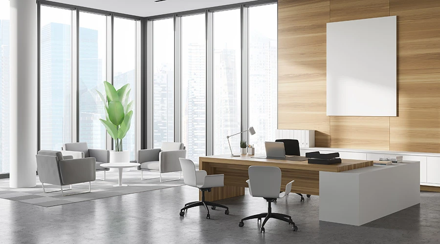 Ufficio direzionale moderno luminoso con scrivania direzionale e area conversazione con poltrone e tavolino