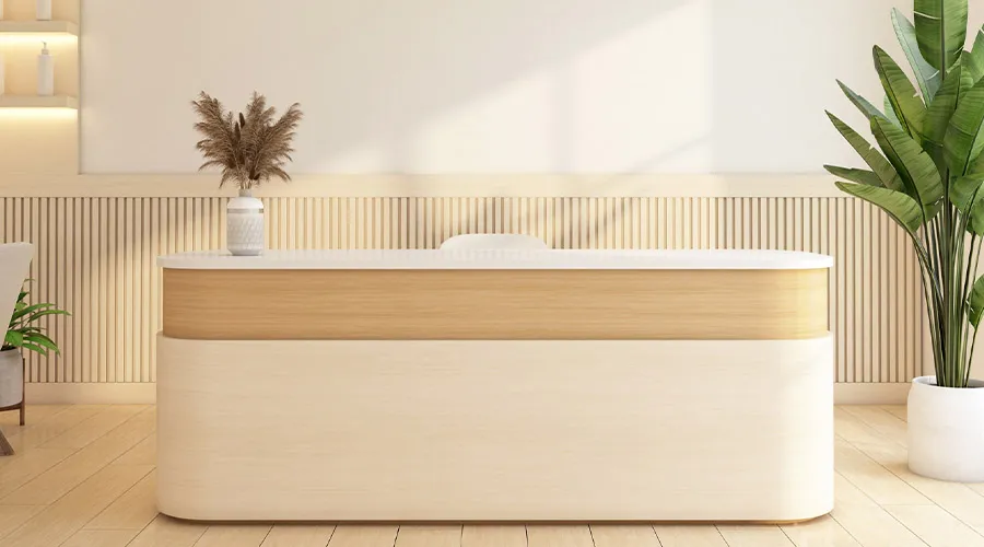 Banco reception moderno in legno con linee arrotondate, piante decorative e ambiente luminoso dallo stile minimal e naturale