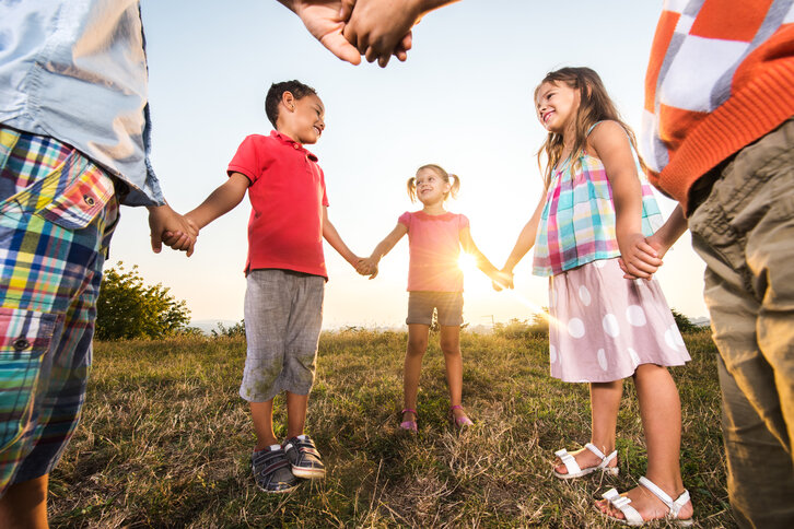 Below view of small happy friends holding hands at sunset. Assortimento Back ti School Mondoffice