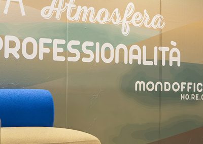 Parete dello stand Mondoffice Ho.Re.Ca. a Hospitality 2026 con la scritta Professionalità e il logo aziendale