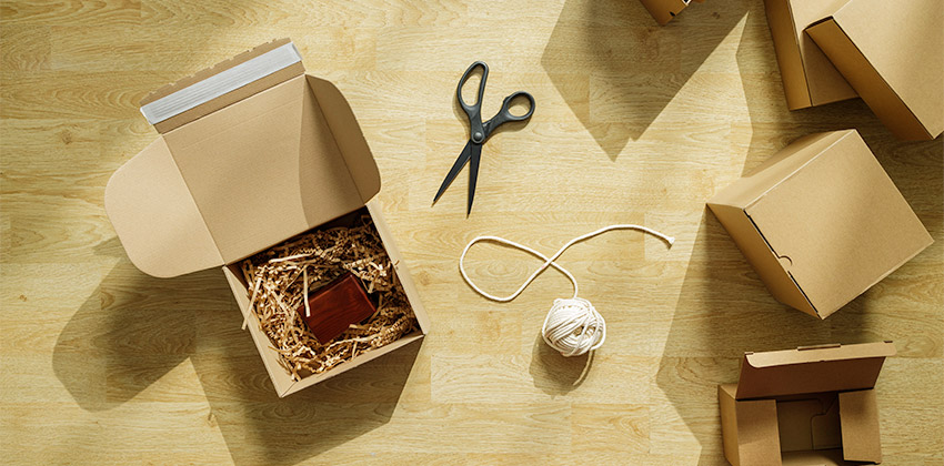 Diverse scatole per spedizioni in cartone con materiale di riempimento e strumenti per il packaging e-commerce