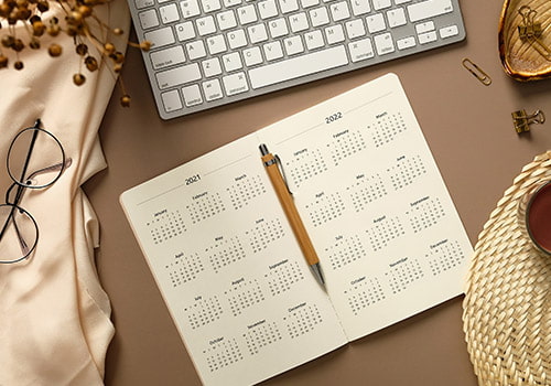 Agenda aperta con calendario annuale su una scrivania